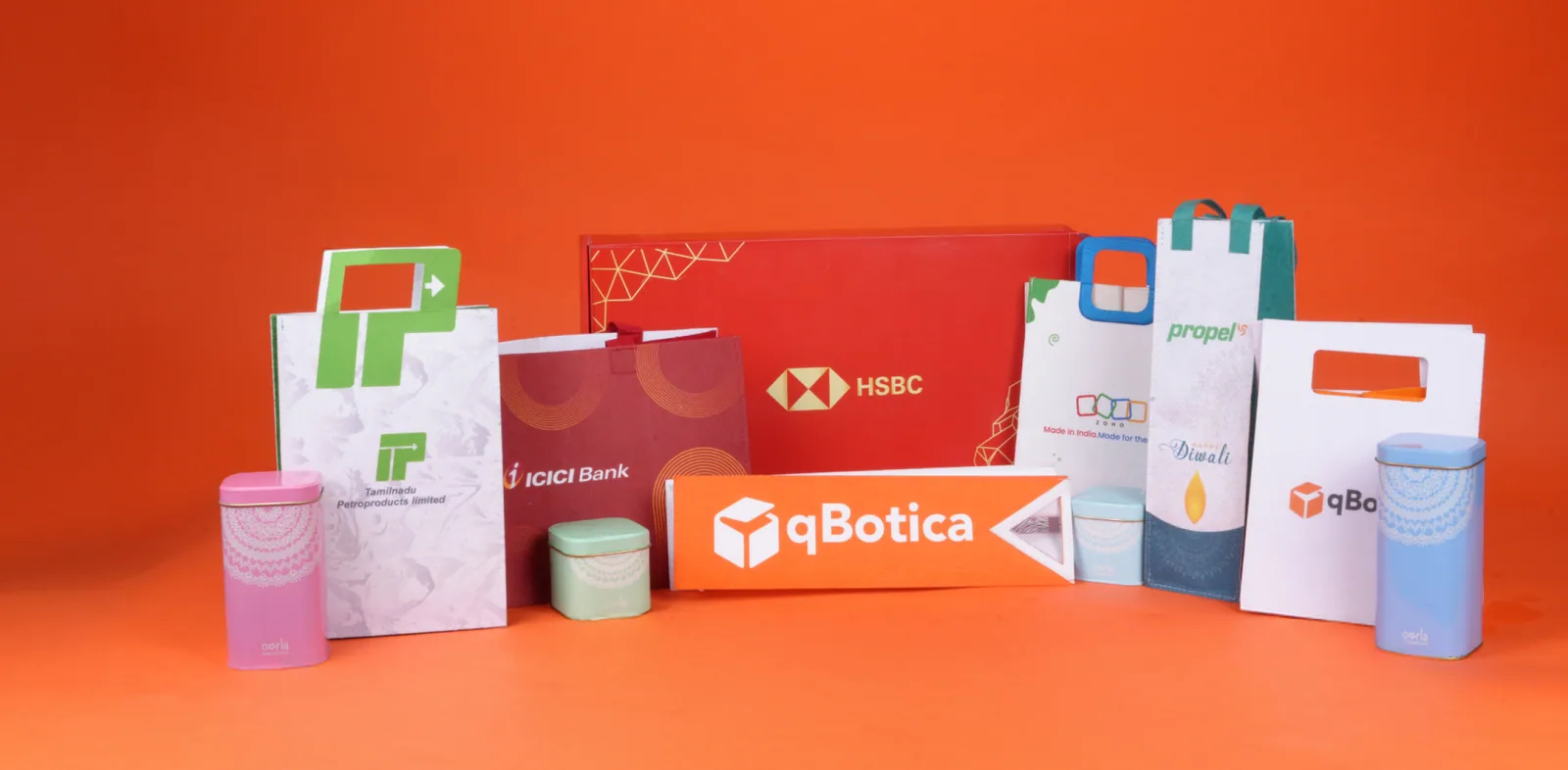 Branded boxes and bags for HSBC, ICICI Bank, ZOHO, Propel, qBotica and Tamilnadu Petroproducts on an orange ground