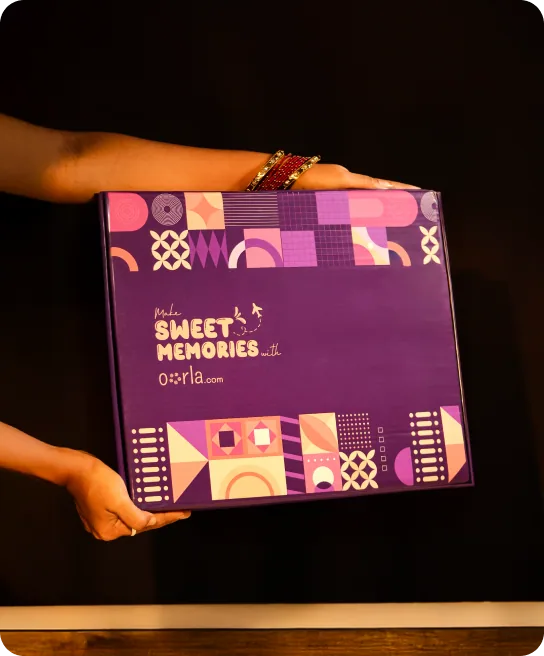Hands holding a purple Oorla gift box printed 'Make sweet memories'