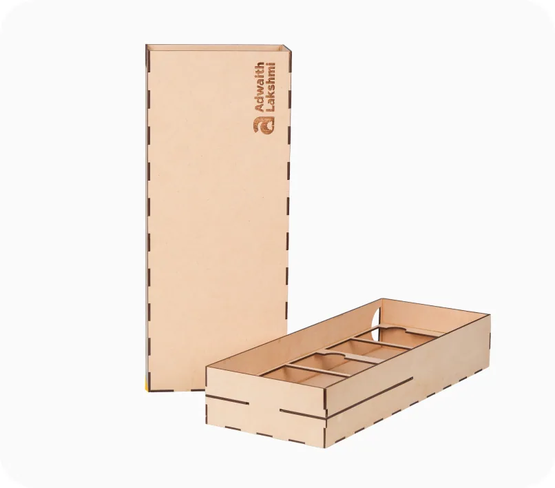 A laser-cut wooden gift box etched with the Adwaith Lakshmi name, beside its compartment tray