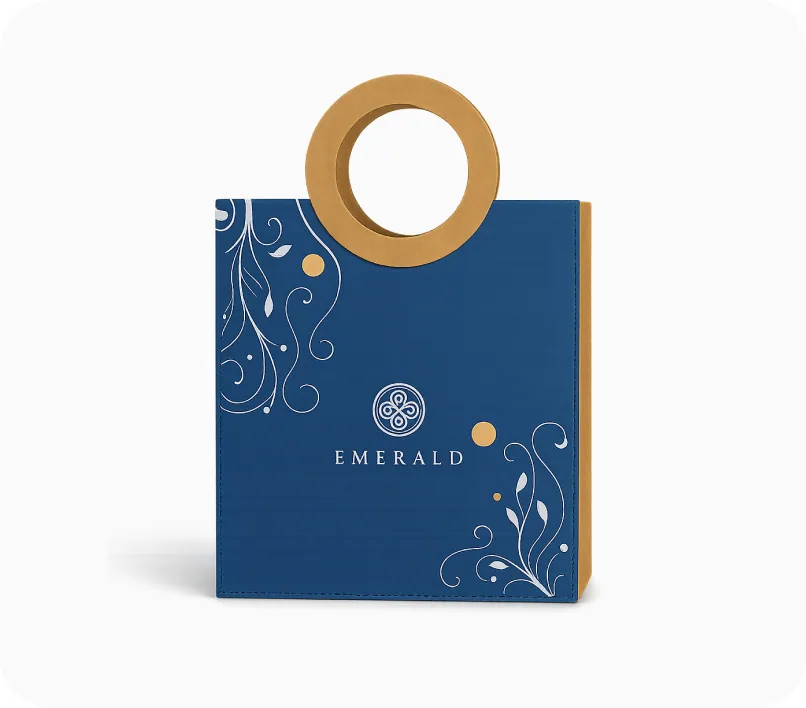 A navy Emerald gift bag with a round gold ring handle and white filigree artwork