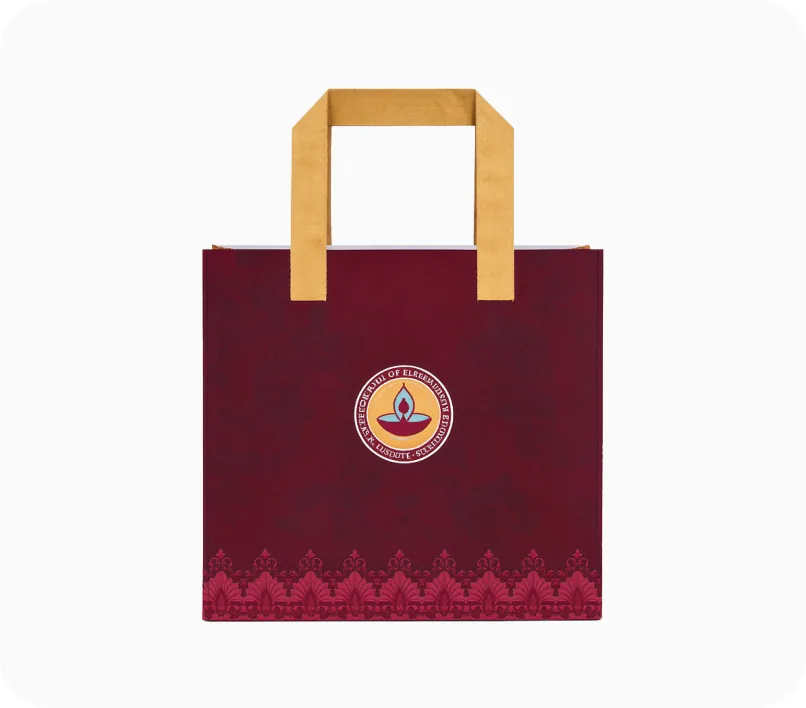 A deep maroon carry bag with kraft paper handles, a circular lamp crest and an ornamental printed border