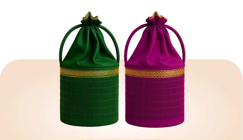 Korai Return Gifts: two woven Korai grass potli baskets with gold zari bands and fabric drawstring tops, one green and one magenta.