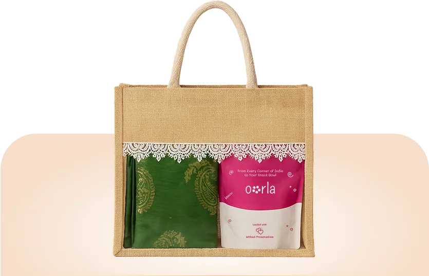 Premium Jute Bags: a laminated jute carrier with rope handles and a white lace panel, holding a green silk pouch and a pink Oorla snack pack.